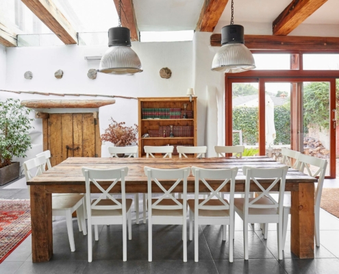 wood dining table with white chairs and wood accents in the room